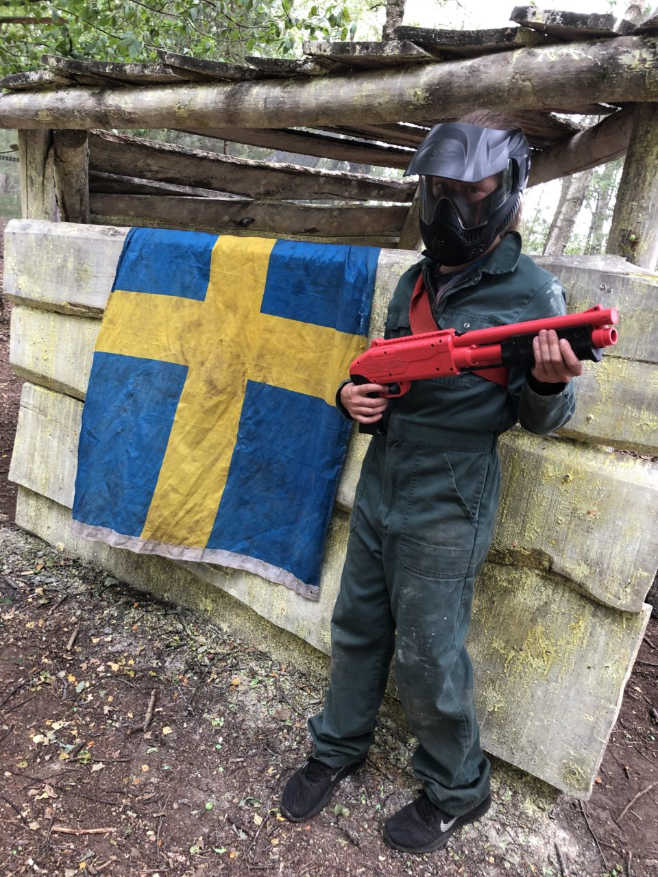 Kind staat naast vlag in kinderpaintballveld