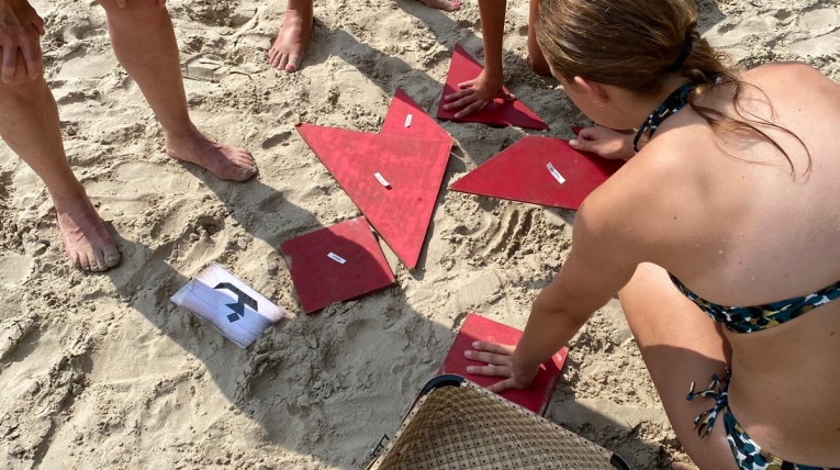 Expeditie Robinson puzzelproef bij Outdoor Challenge Park waarbij een team samenwerkt aan een strategische opdracht